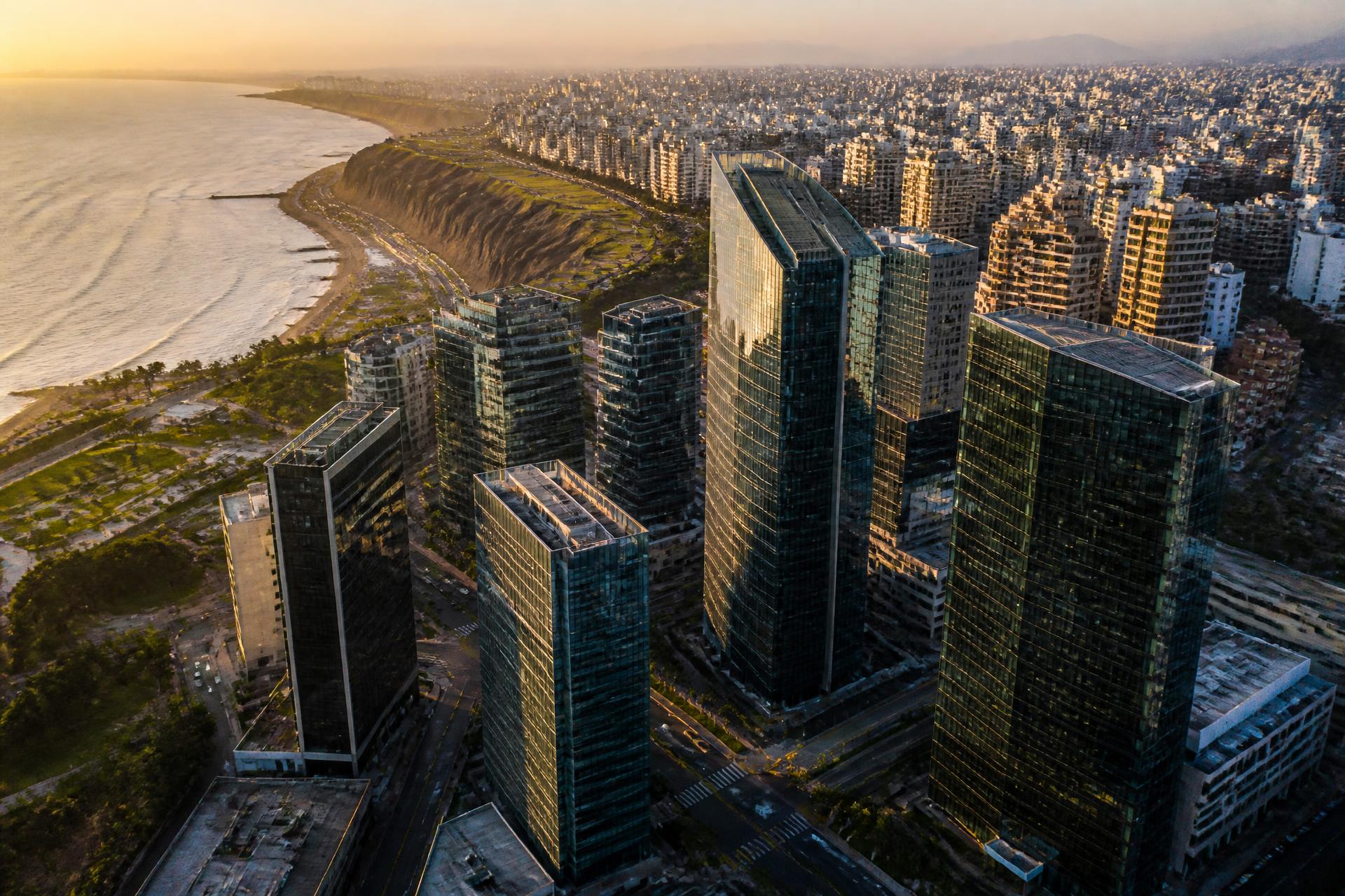 Skyline corporativo de San Isidro y Miraflores en Lima con la Costa Verde al atardecer